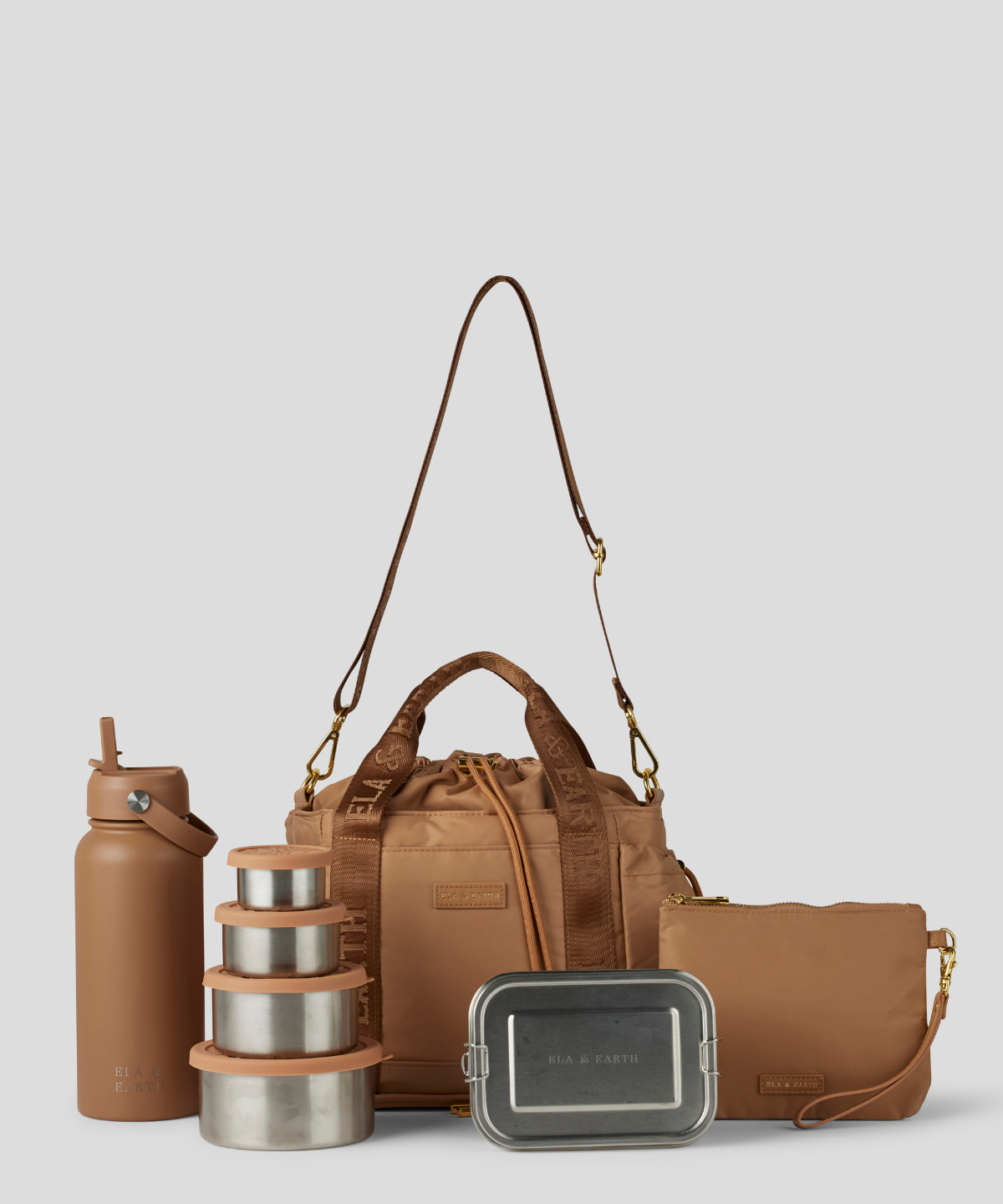 The Biscuit lunch bucket bag  set from  including a black insulated water bottle, a stack of stainless steel lunch containers with sage green lids, and a black zip pouch with gold hardware, arranged on a light gray background.