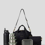 The Black lunch bucket bag  set from  including a black insulated water bottle, a stack of stainless steel lunch containers with sage green lids, and a black zip pouch with gold hardware, arranged on a light gray background.