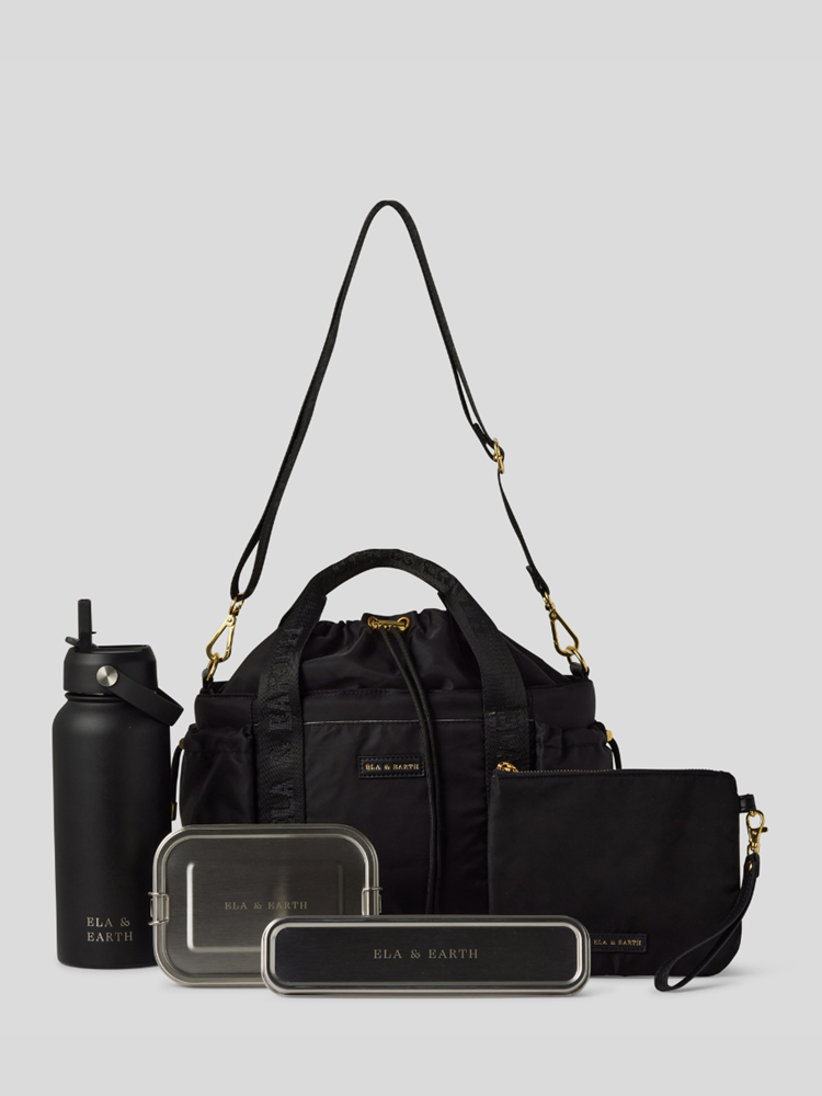 Black Lunch Bucket Bag set on a light gray studio background. The set includes a tan canvas duffel bag with a long shoulder strap, a matching tan pouch, a brown bottle, a dark gray lunch box, and a black lunch box with gold hardware