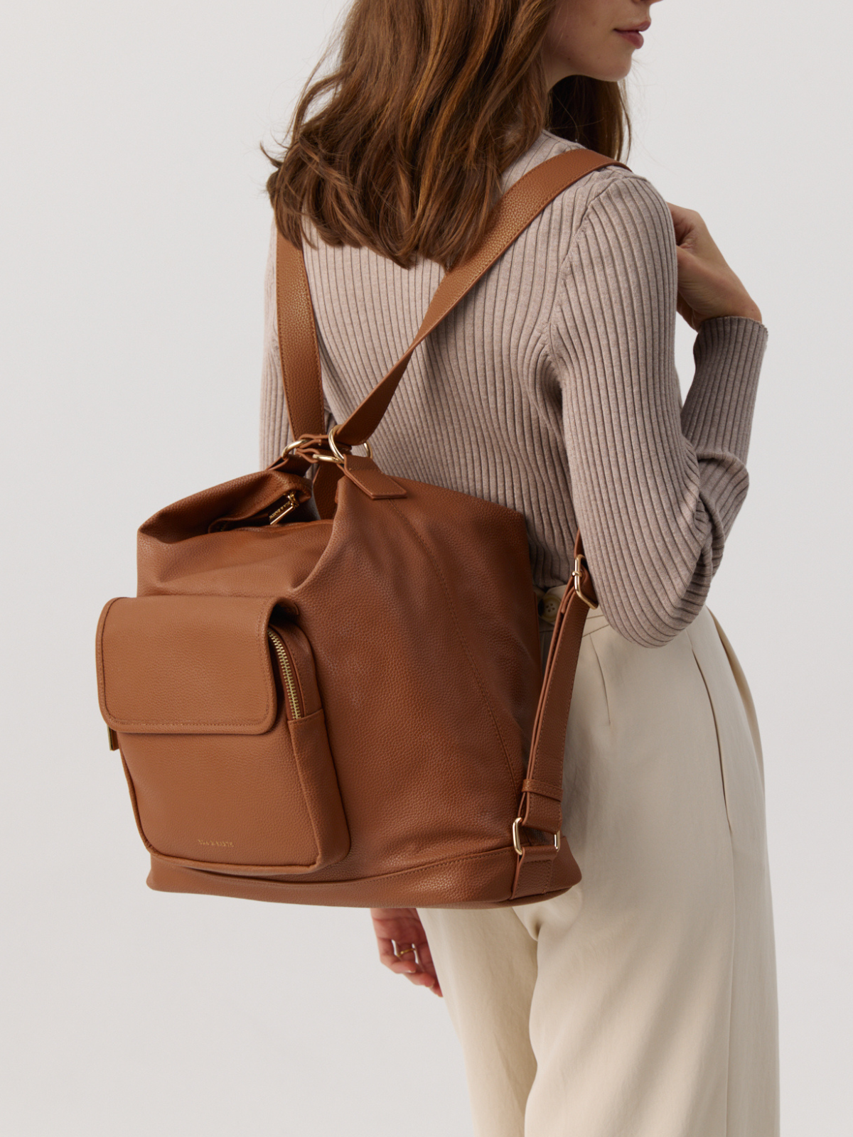 Model holding Arden Caramel Backpack
