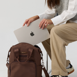 Model holding a laptop to put inside the Cocoa Backpack 