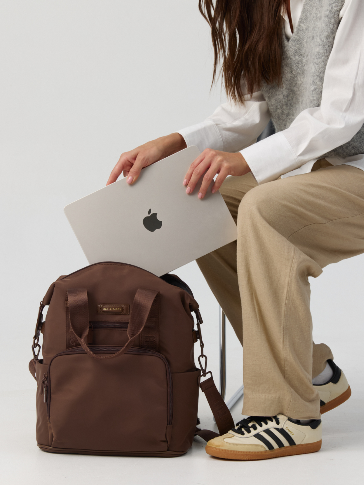 Model holding a laptop to put inside the Cocoa Backpack 