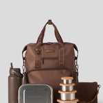 Cocoa backpack with water bottle, lunch box, and containers on a light gray background