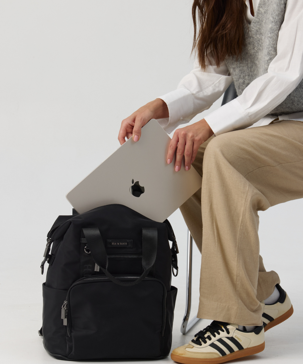 Model holding a black backpack 
