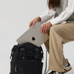 Model holding a black backpack 
