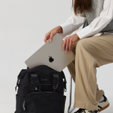 Model holding a black backpack 