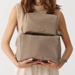 Model holding the Toiletries Pouch and the Cosmetic Pouch 