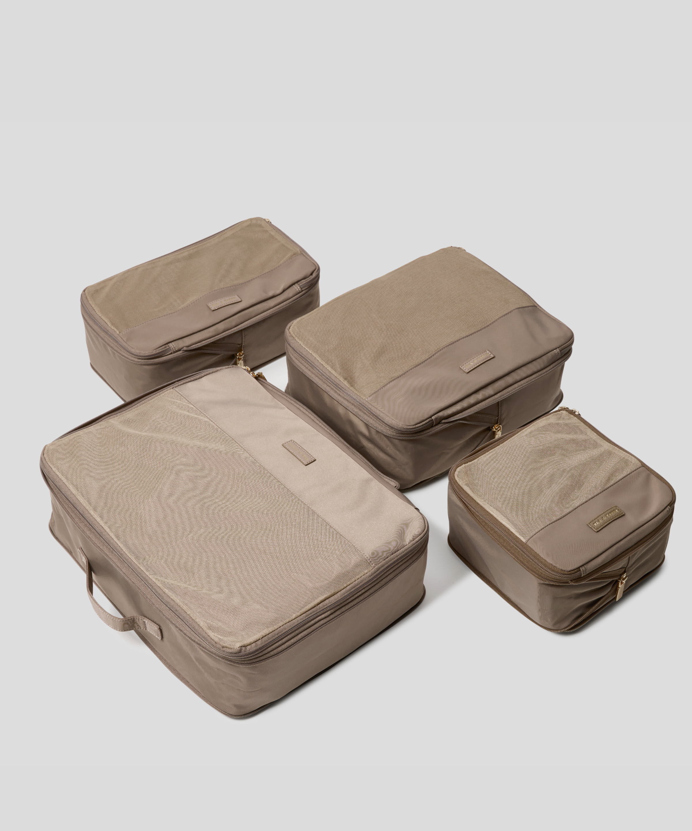 Four Oyster packing cubes of different sizes arranged on a light gray background.