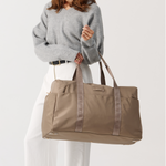 Model holding a weakeneder travel bag 