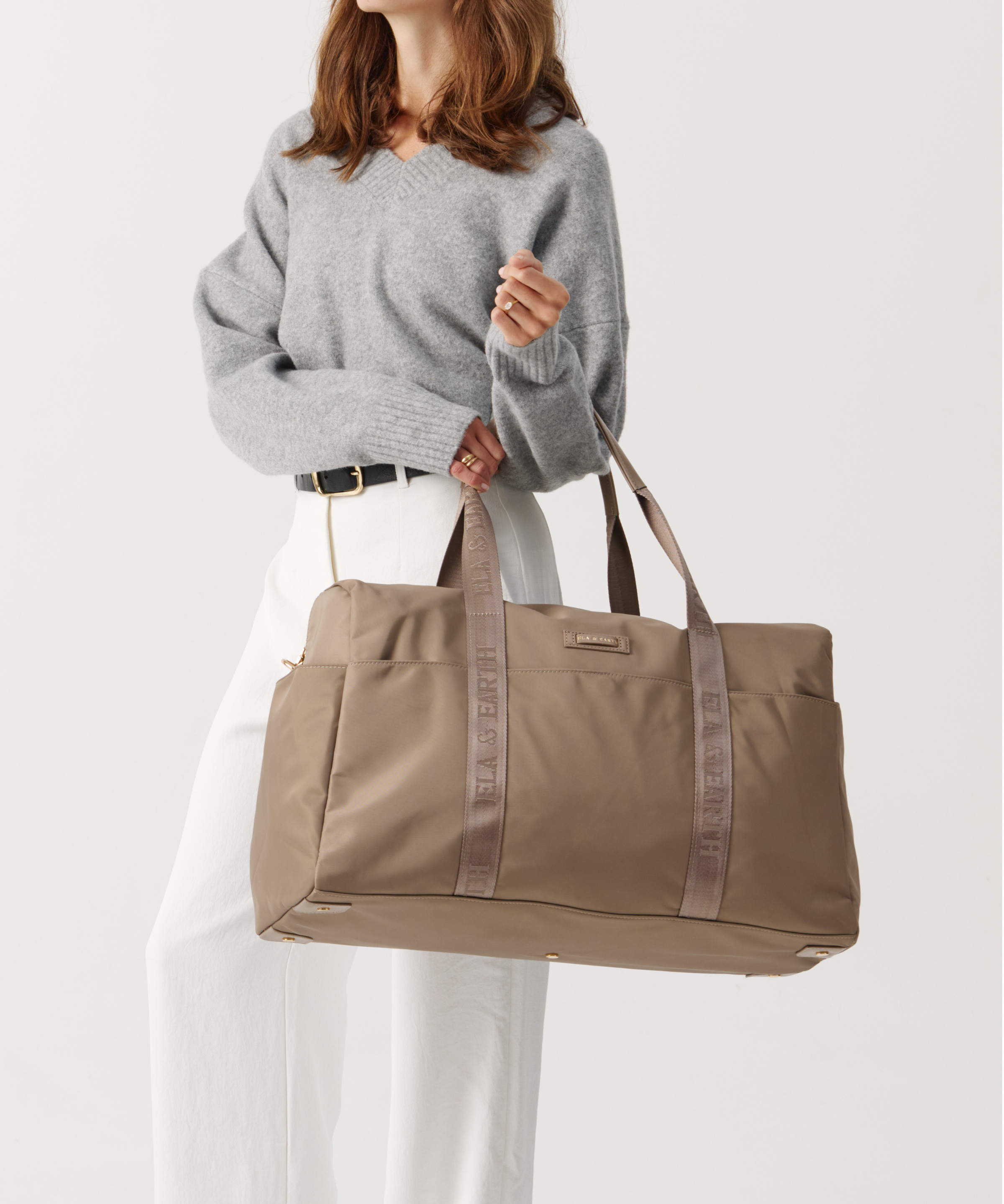 Model holding a weakeneder travel bag 