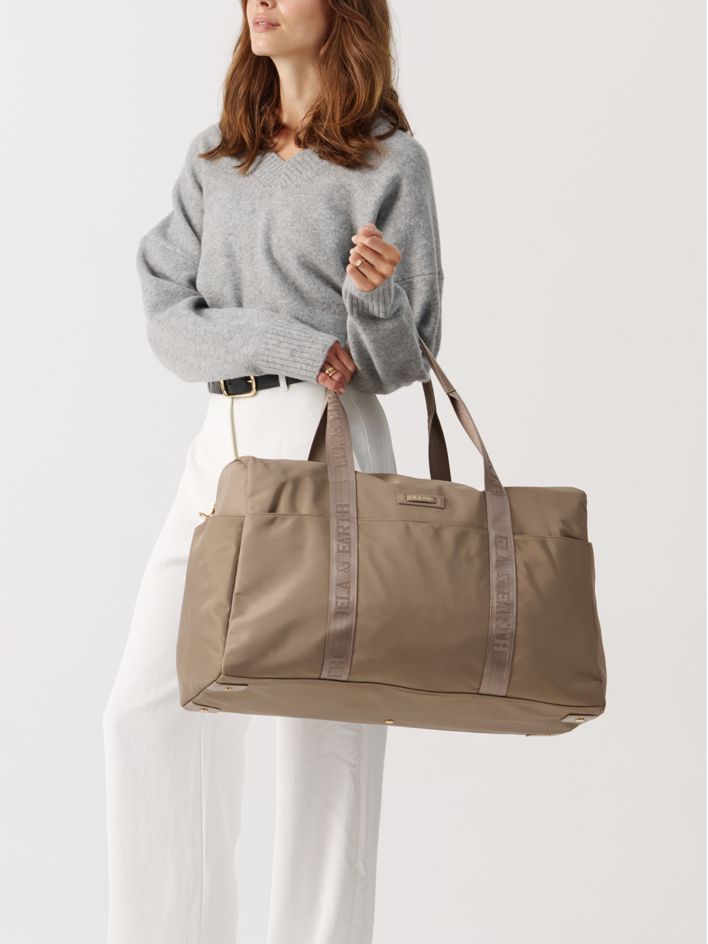 Model holding a weakeneder travel bag 
