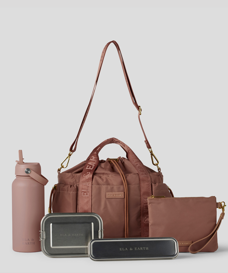 Rose  Lunch Bucket Bag set on a light gray studio background. The set includes a tan canvas duffel bag with a long shoulder strap, a matching tan pouch, a brown bottle, a dark gray lunch box, and a black lunch box with gold hardware