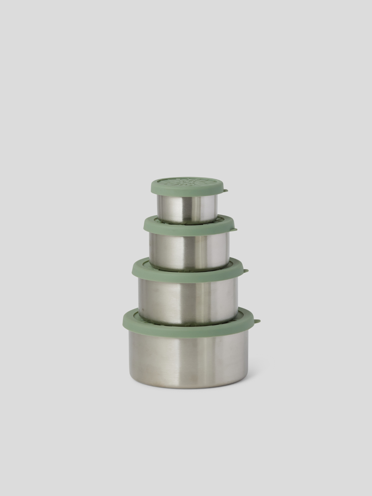 Four nested stainless steel lunch containers with matching sage green lids, arranged in descending size order on a light gray background.